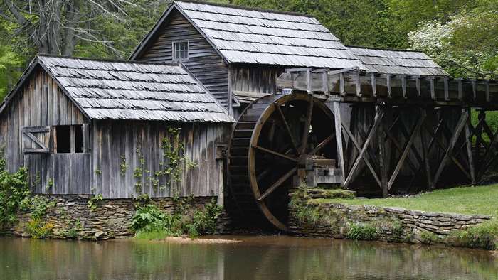 Rustic wooden water mill by a river