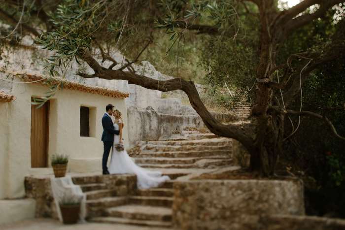 Wedding couple in Greece near a rustic house and stairs