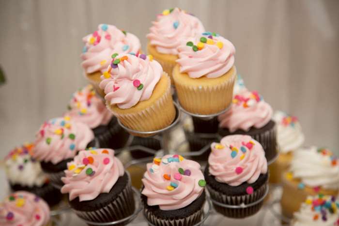 Pink Frosted Cupcakes with Sprinkles on a Tiered Stand