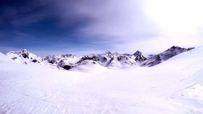 Snowy mountain landscape with a vast sky