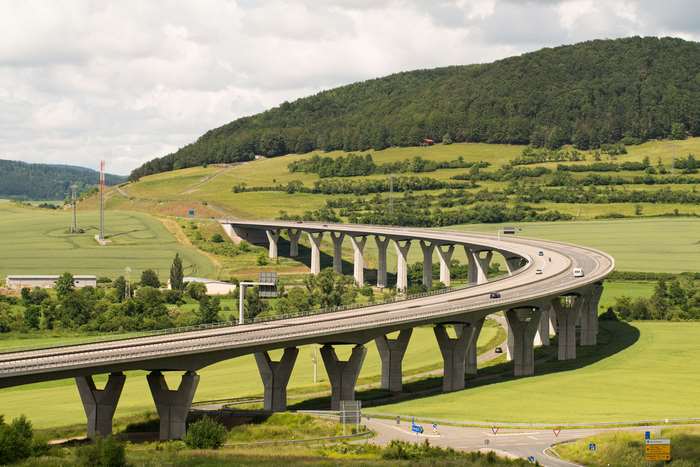 Curving highway bridge over green fields in Germany 4K