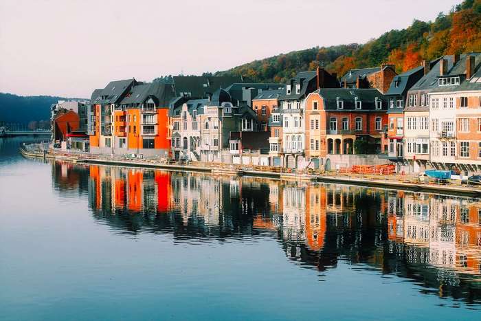 Colorful buildings reflected in a river in Dinant, Belgium