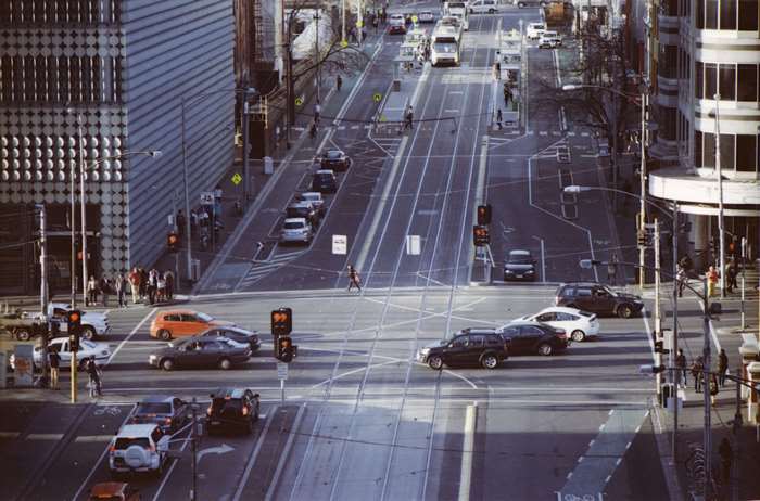 Melbourne CBD street with trams, cars, and pedestrians