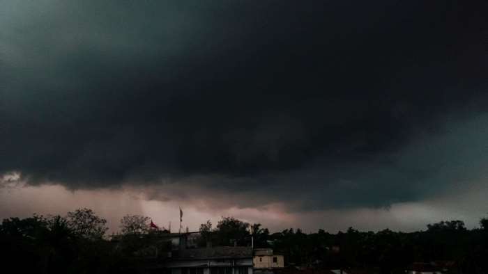 Dark storm clouds over a town with trees