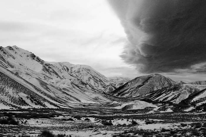 Snow-capped mountains under dark storm clouds in New Zealand 4K