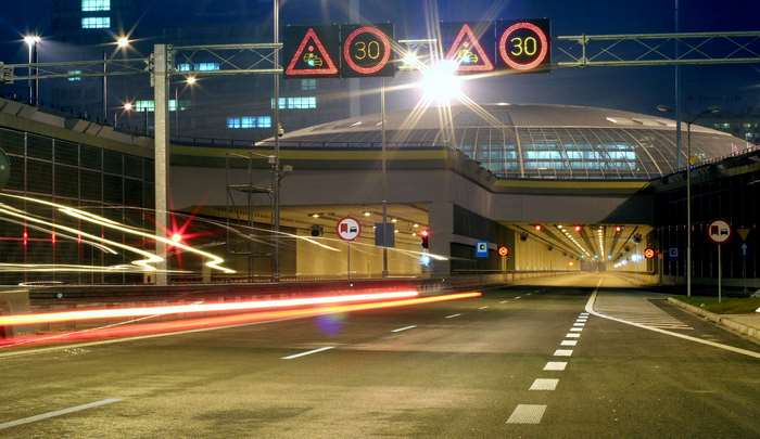 Night view of a tunnel entrance with speed limit signs