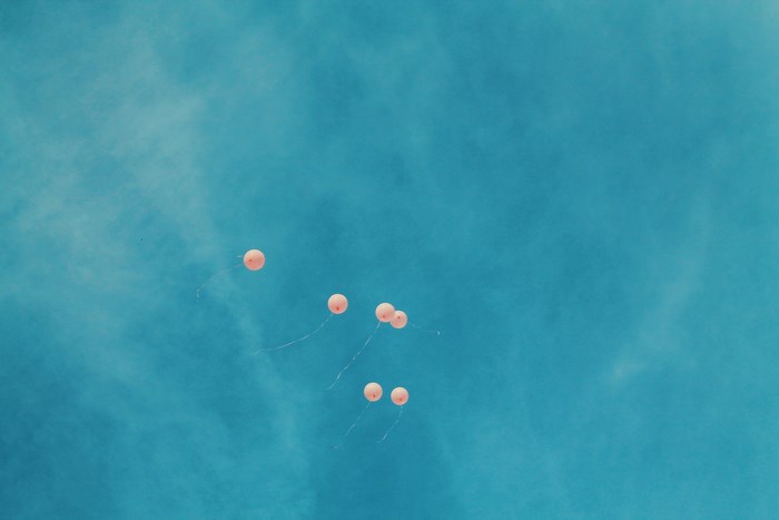 Pink balloons floating in a blue sky