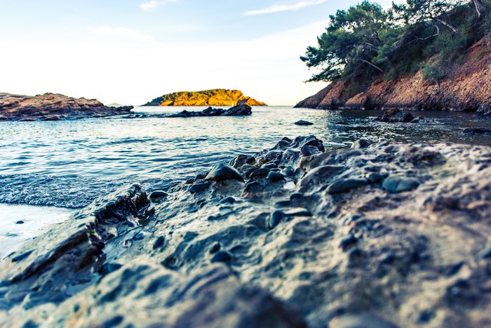Close-up of rocks on a beach with the sea and an island in the background