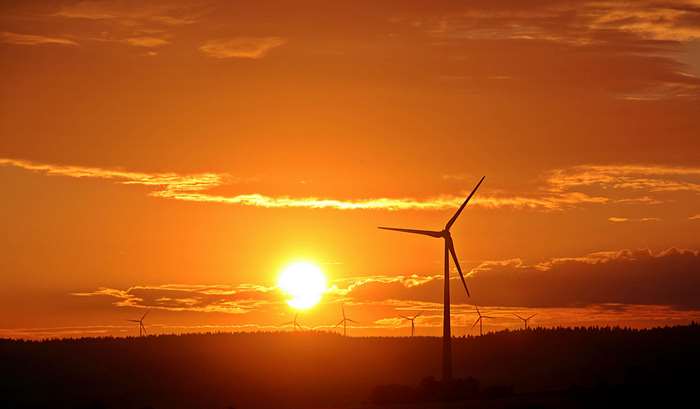 Wind turbines at sunset with orange sky