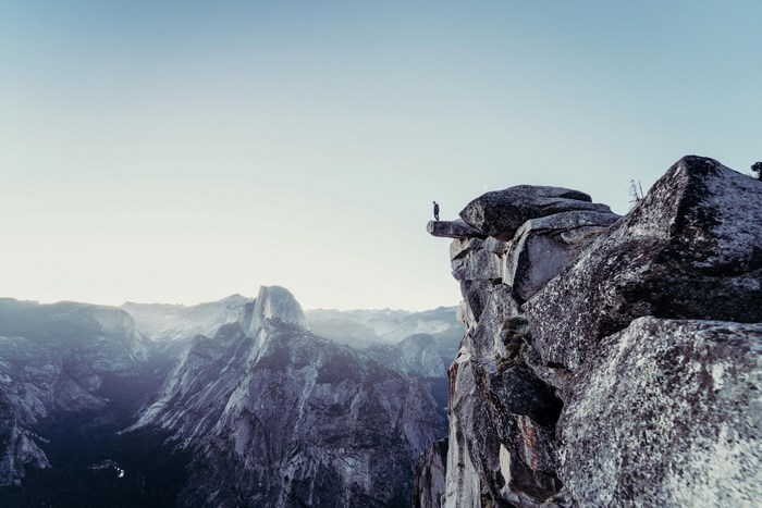 Man standing on a cliff edge in Yosemite National Park