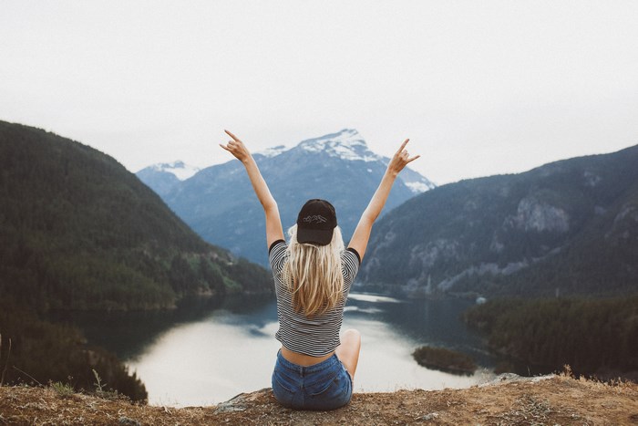 Woman with arms raised in mountains