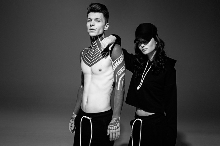Man with tattoos and woman in black hoodie