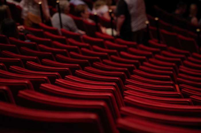 Red theater seats with blurred audience