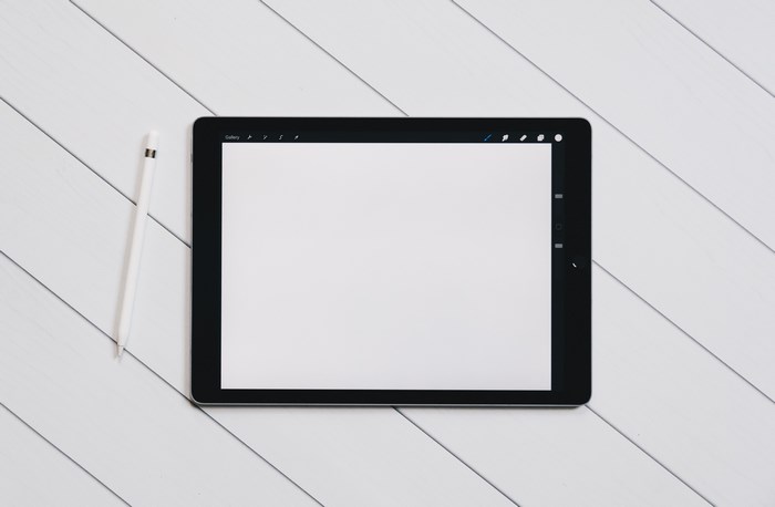 Black iPad Pro with Apple Pencil on White Wood Surface