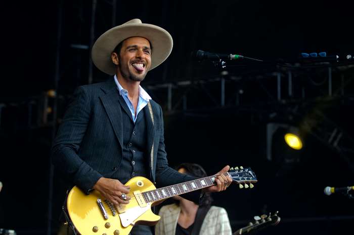 Man in cowboy hat playing guitar on stage