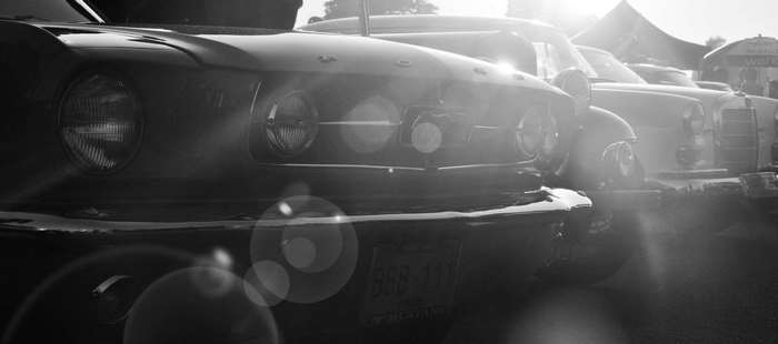 Black and white image of classic cars at a car show