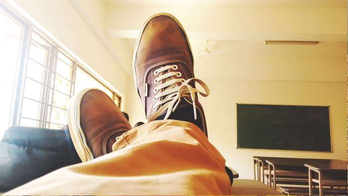 Person wearing Vans shoes in a classroom