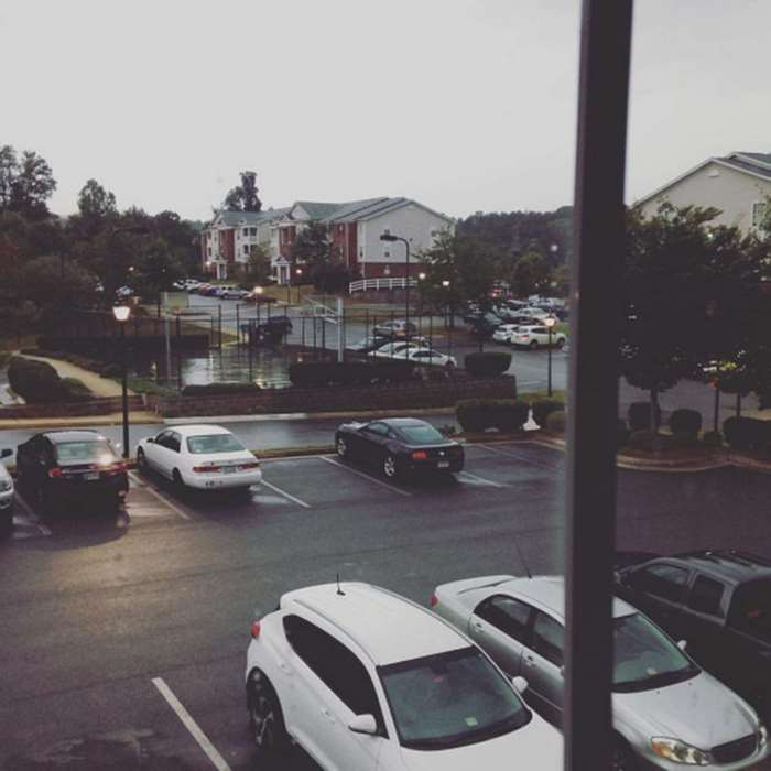 Apartment parking lot with cars on a rainy day
