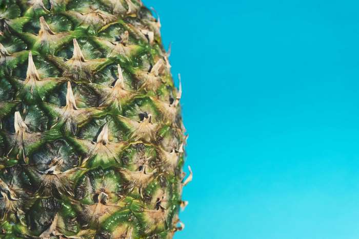 Close up of pineapple texture on blue background 4K