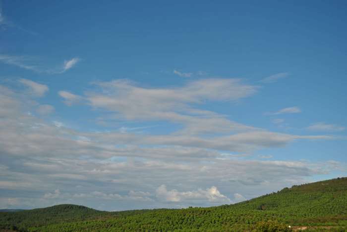 Green hills under a cloudy blue sky
