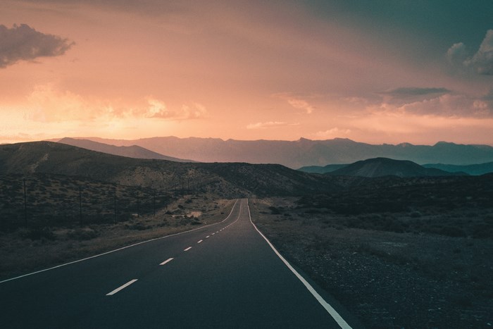 Road through mountains at sunset