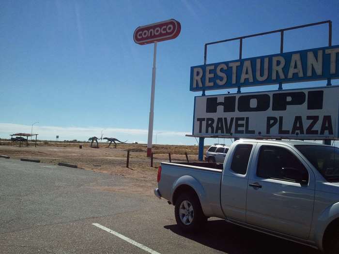Conoco and Hopi Travel Plaza sign with dinosaur statues