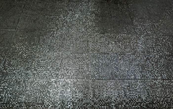 Textured grey floor tiles with glare