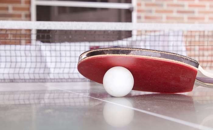 Table tennis paddle and ball on table