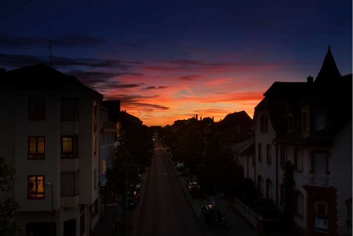 Street at dusk with colorful sunset over buildings