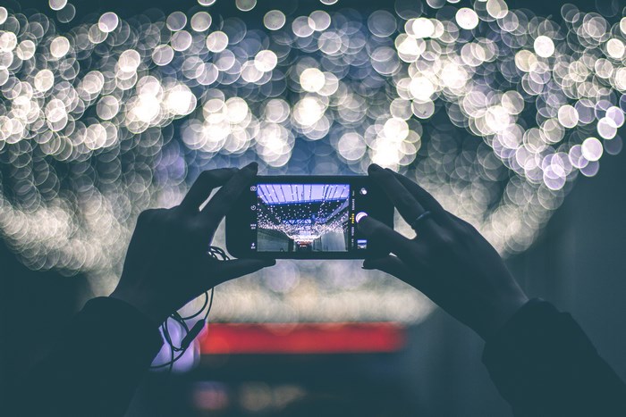 Person taking a photo of bokeh lights with an iPhone