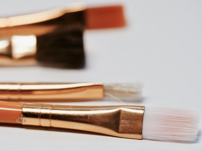 Paintbrushes with gold handles on a white background