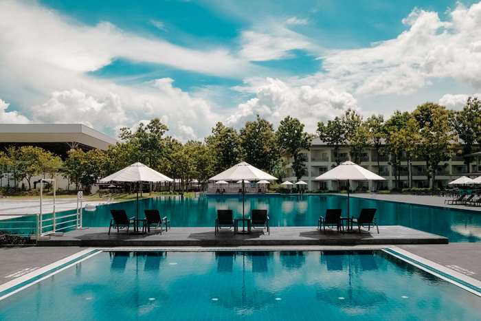 Luxury resort swimming pool with lounge chairs and umbrellas