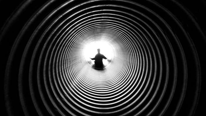 Silhouette of a person in a corrugated tunnel