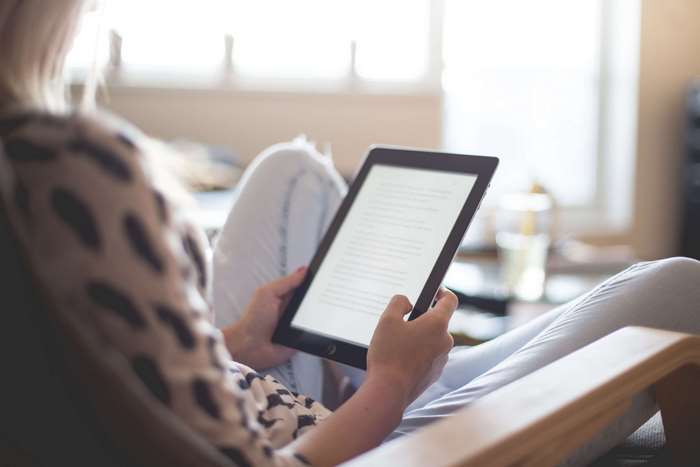 Woman reading on a tablet in a living room