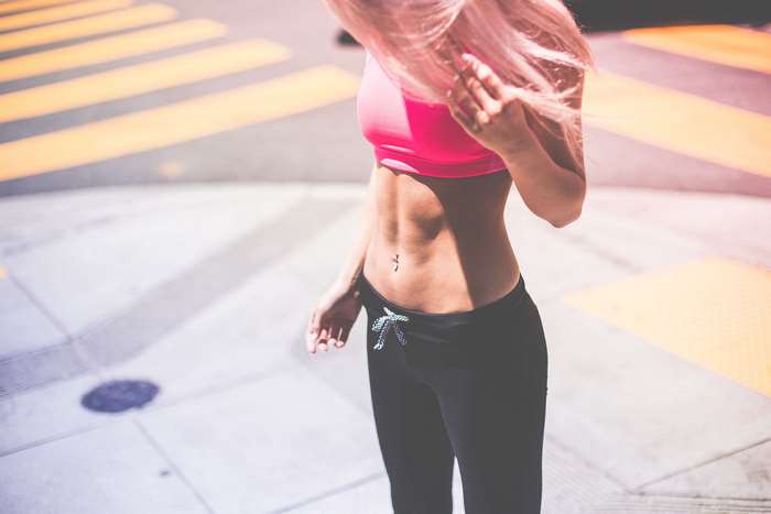 Woman with pink hair in sportswear on street