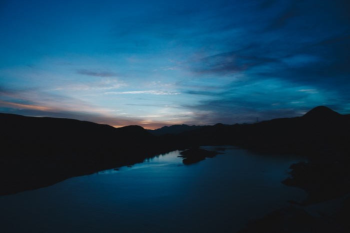 Silhouette of mountains and lake at sunset