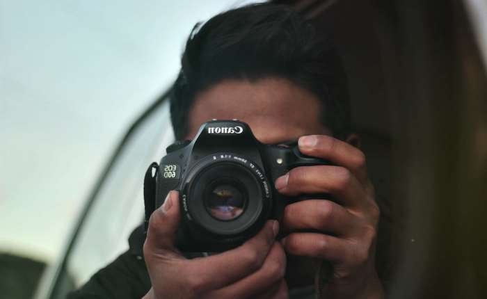Man taking a photo with a Canon DSLR camera