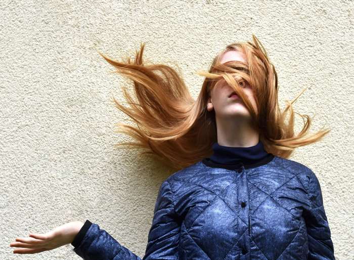 Young woman with red hair flying in the wind