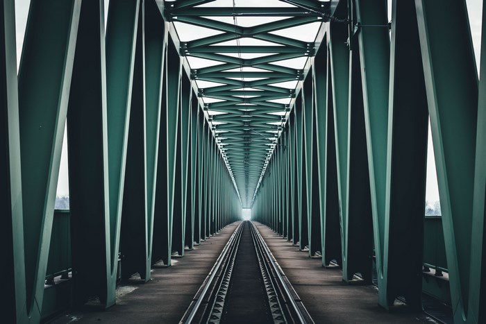 Perspective view of a railway bridge with green metal structure