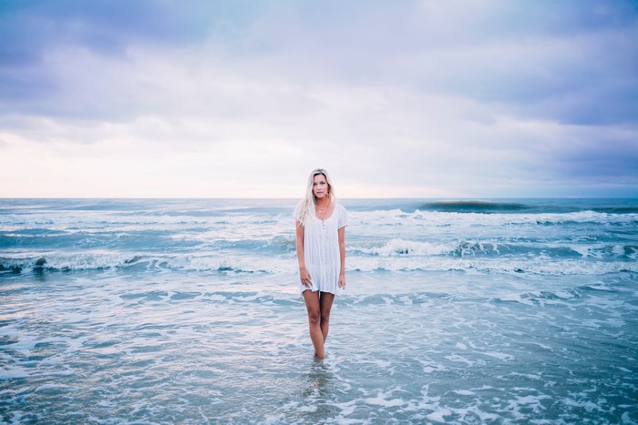 Woman in white dress standing in the ocean