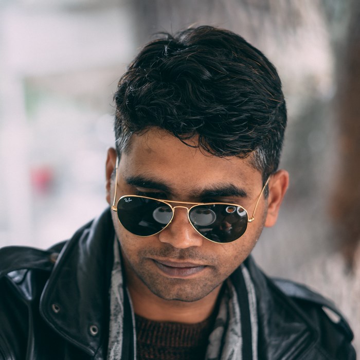 Man wearing Ray-Ban sunglasses and leather jacket