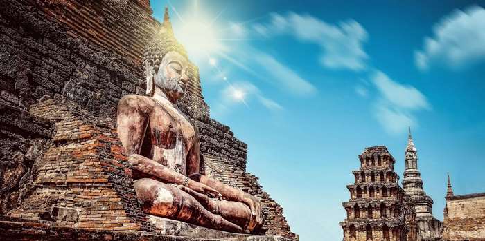 Buddha statue in ancient ruins under the sun