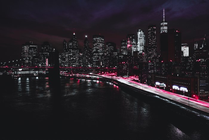 New York City skyline at night with bridge and river