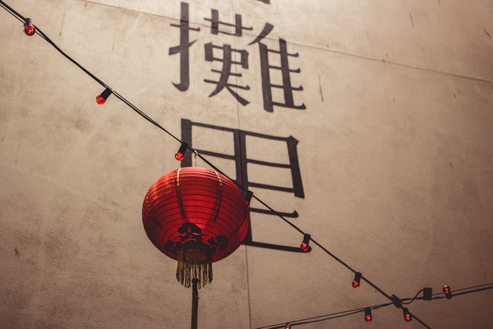 Red Chinese Lantern and Asian Characters on Wall