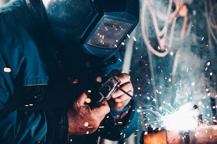 Welder wearing mask and working with sparks