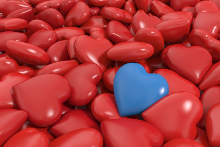 A pile of red hearts with one blue heart
