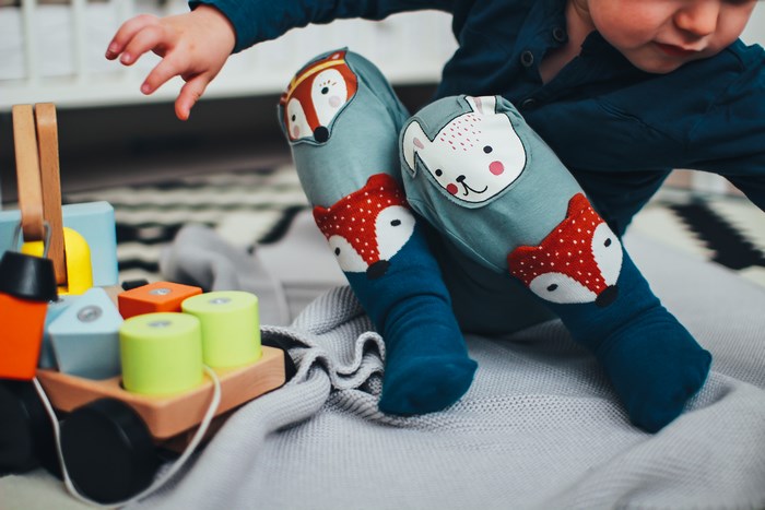 Toddler playing with wooden blocks and toys