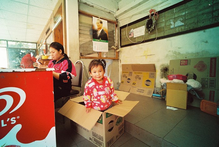 Girl playing in a cardboard box in a store