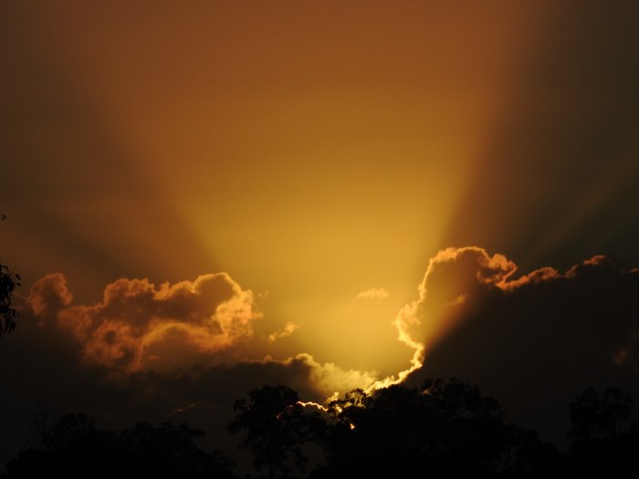 Sunlight beams through clouds at dawn