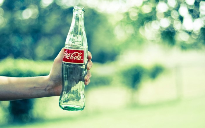 Hand holding a Coca-Cola bottle